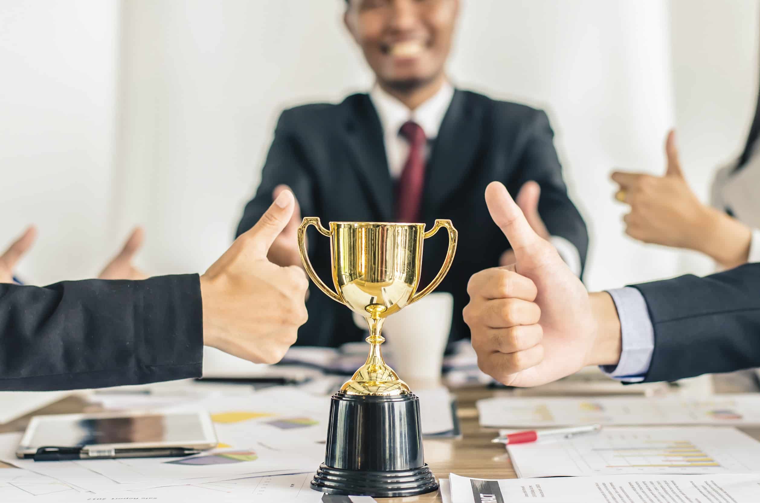 un groupe de personnes assises autour d'une table avec un trophée