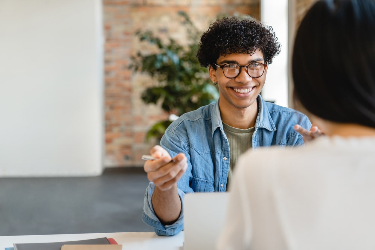 un homme assis à une table parlant à une femme